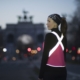 photo of a woman in reflective running gear t-shirt from Vespertine with a bright reflective "X" on the back of her shirt.