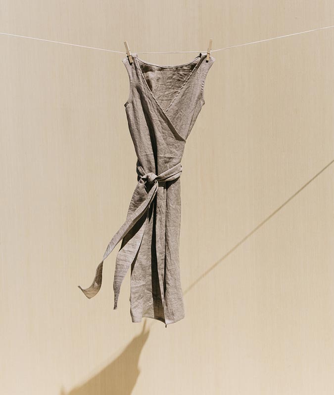 The Kayo wrap dress in flx linen hanging from a clothesline