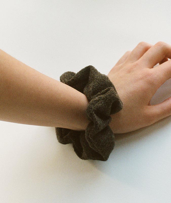 Photo of the Umber Wool Scrunchie on a woman's wrist.