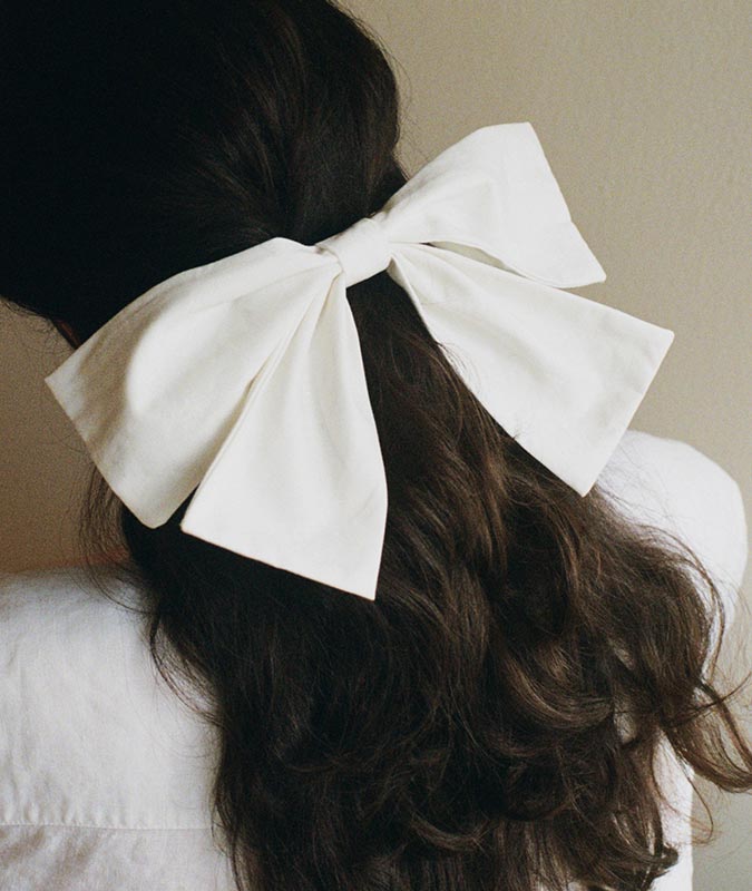Photo of the wide large bowtie in snow holding a low, loose ponytail on a womans head